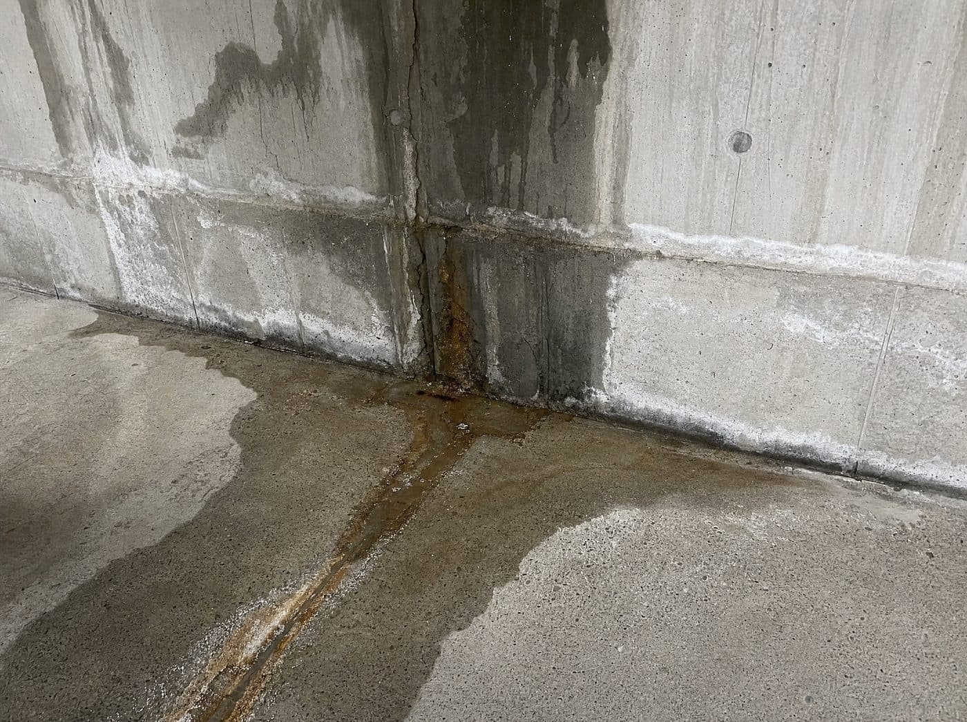 Active water seepage on a commercial parking garage concrete wall before repair